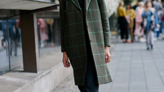 Street style traje negro y abrigo de cuadros