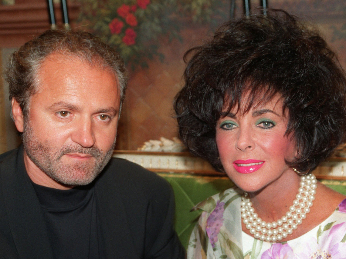 Italian fashion designer Gianni Versace is seen with actress Elizabeth Talyor while inaugurating his shop in Paris in this June 1991 photo. (AP Photo/Laurent Rebours)© RADIAL PRESS