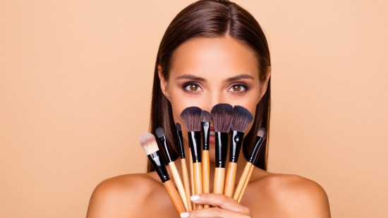 mujer con brochas de maquillaje