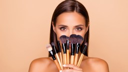 mujer con brochas de maquillaje