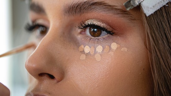 Mujer maquillándose con corrector