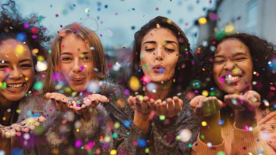 amigas soplando confetti