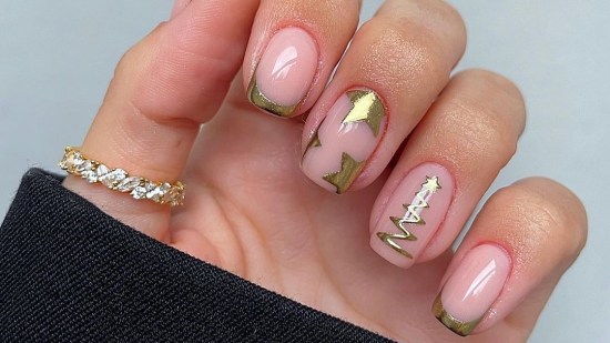 Manicura dorada con estrellas de Navidad
