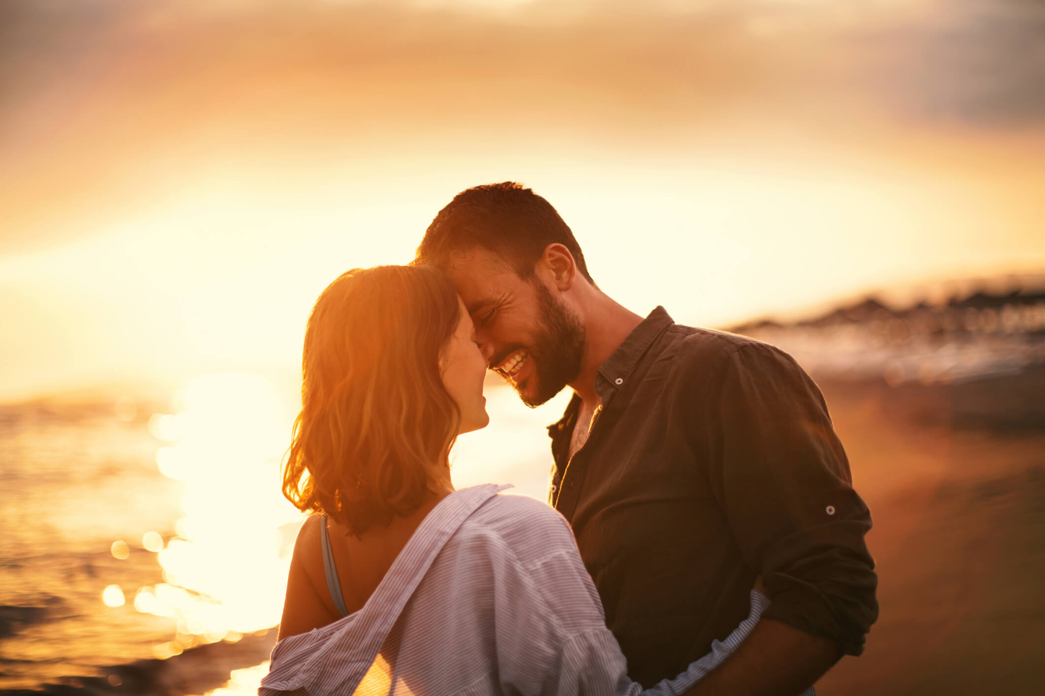 pareja enamorada mirandose sonriendo en la playa