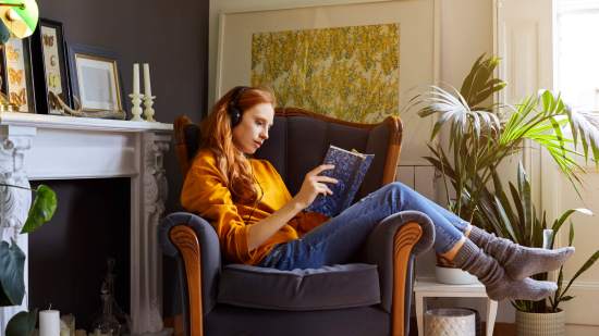 mujer pelirroja leyendo mientras escucha musica
