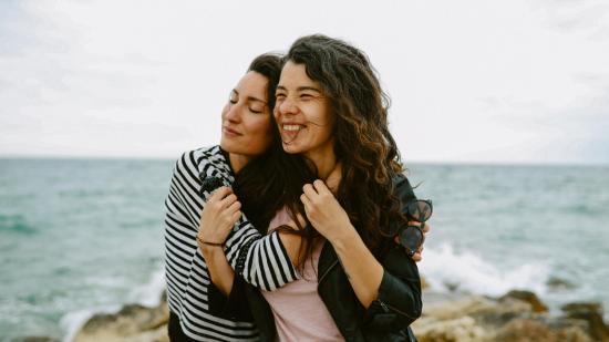 dos amigas abrazandose en la playa