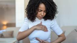 Joven palpando su pecho - iStock