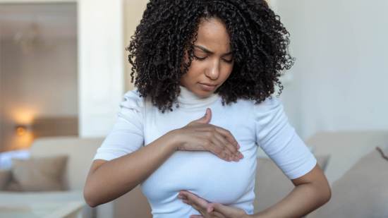 Joven palpando su pecho - iStock