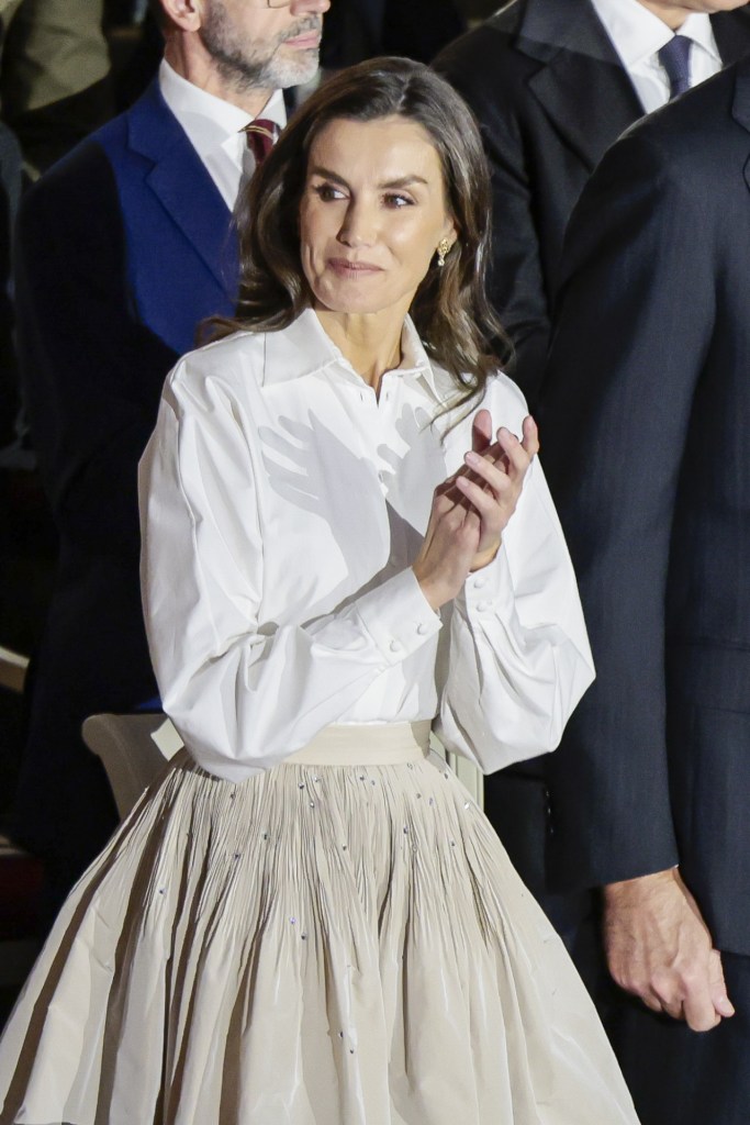 El look de la reina Letizia compuesto por una camisa blanca y falda midi de tafetán - GTRES