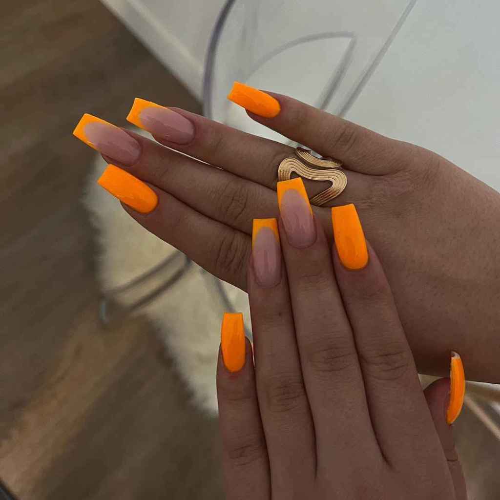 Manicura con detalles naranjas en uñas largas
