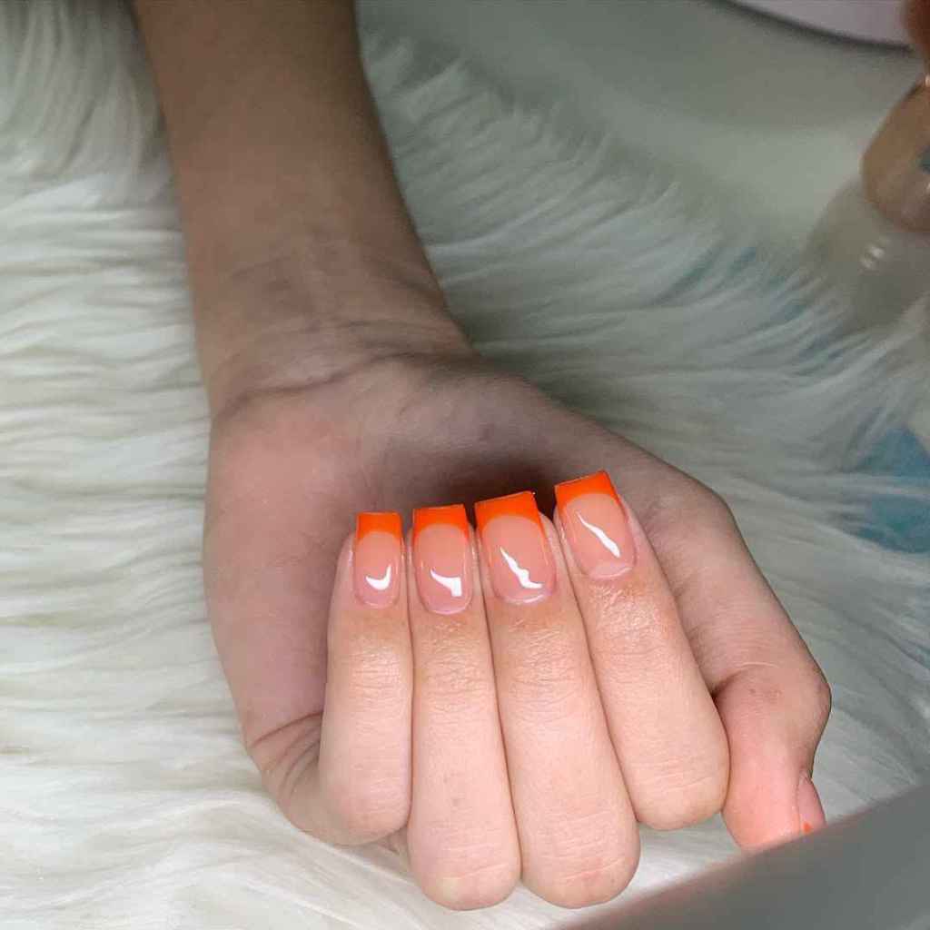 La manicura francesa con toques naranjas es más viva y llamativa