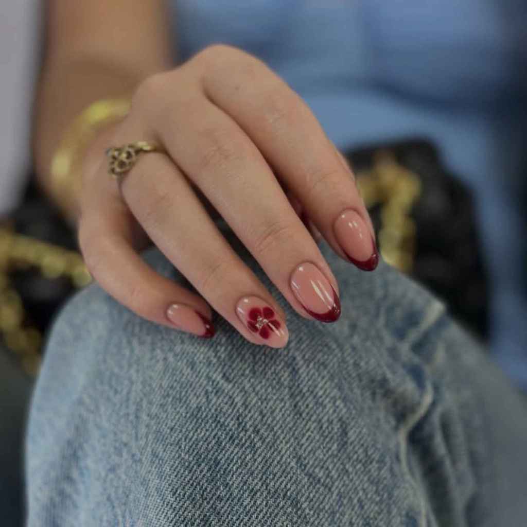 Esta manicura francesa burdeos con detalles de flores es tendencia