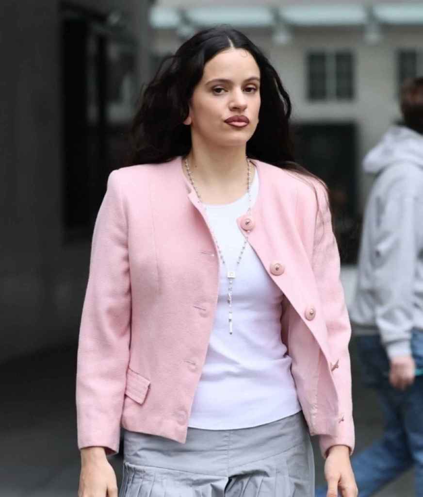 La cantante Rosalía paseando por Londres con un look con chaqueta rosa y rosario 