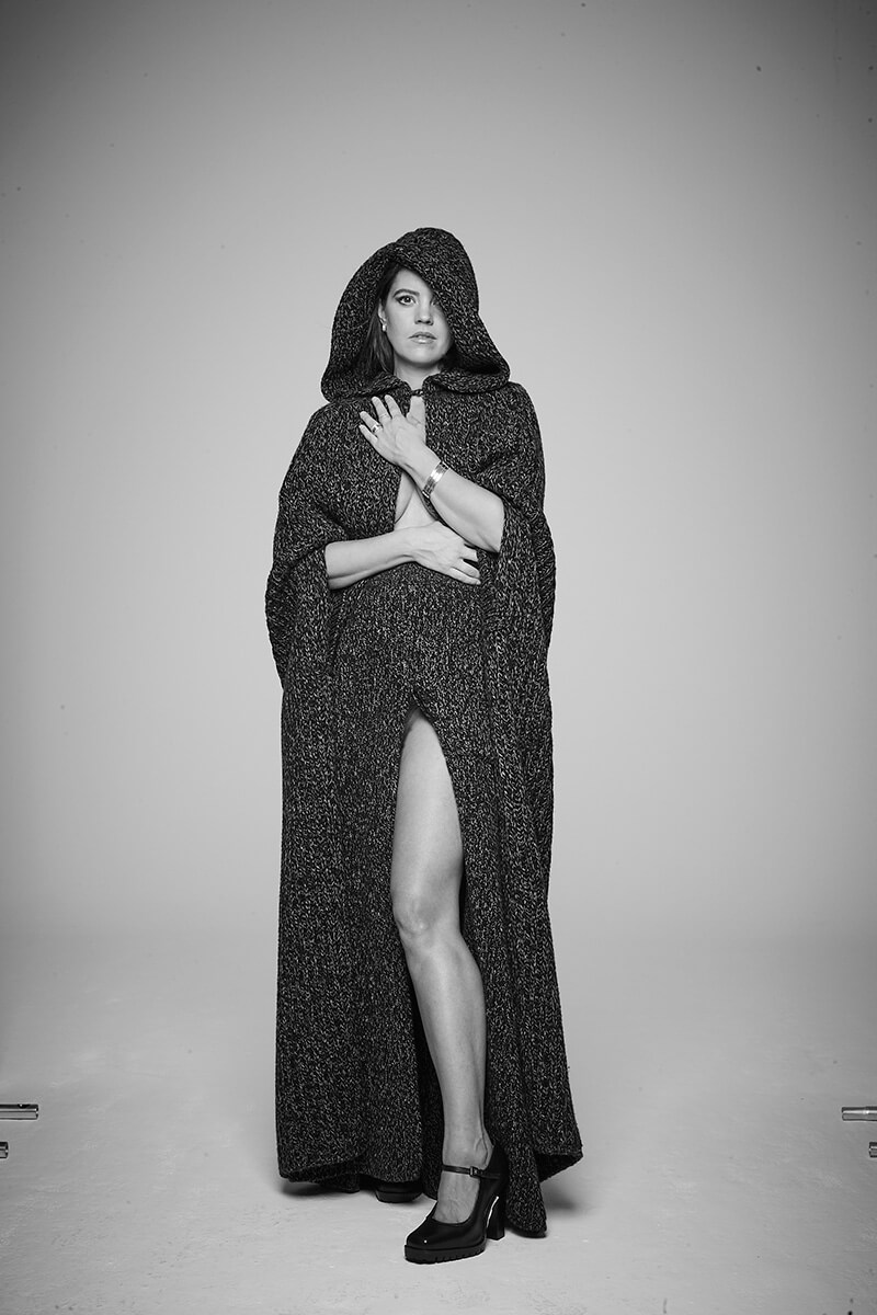 Capa larga y falda acampanada de canalé de lana y cachemira, cinturón largo de piel y merceditas de piel, todo de Max Mara. Pendientes B.zero1 Rock en oro amarillo con pavé de diamantes, pulseras B.zero1 en oro amarillo, oro blanco y oro rosa, y anillos B.zero1 en oro amarillo con pavé de diamantes, todo de Bvlgari.