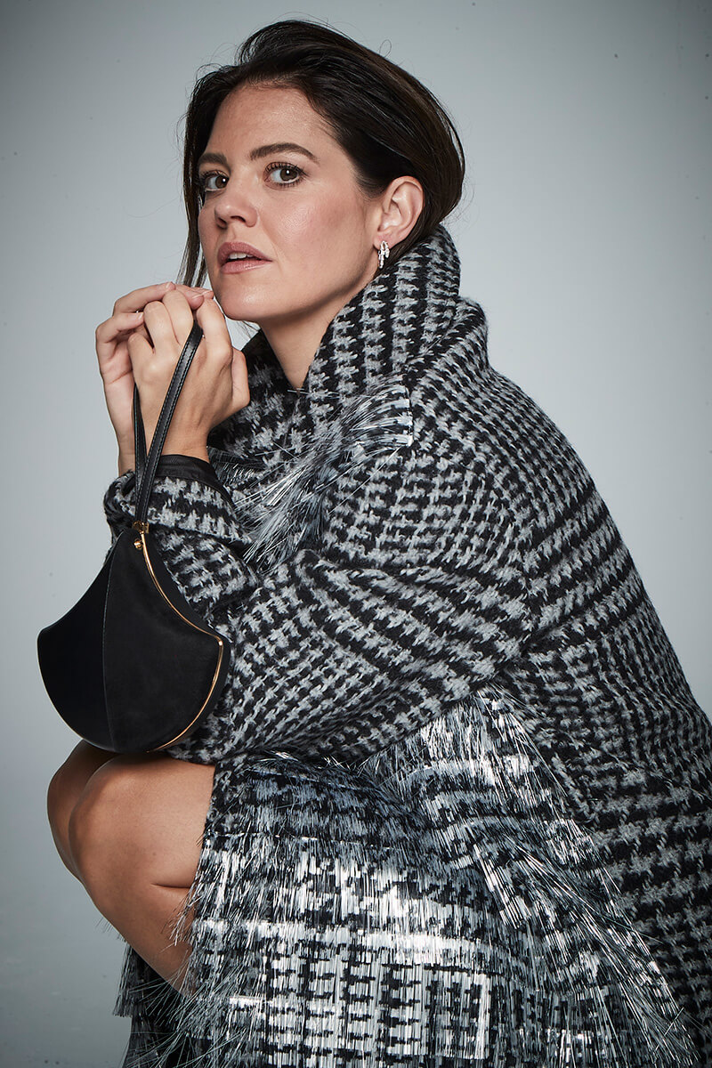 Abrigo en mezcla de lana y mohair, de Loewe. Pendientes Serpenti en oro blanco con pavé de diamantes y bolso Ginkgo en piel de becerro y ante con forro en piel de napa y correa para la muñeca en piel, ambos de Bvlgari.